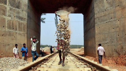 Varios operarios trabajan en la instalación de una nueva vía férrea a las afueras de Agartala, capital del estado indio de Tripura. /JAYANTA DEY (REUTERS)