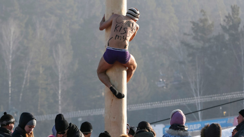 Un hombre sube por un palo de madera hasta una altura de 13 metros para conseguir un premio, durante las celebraciones Maslenitsa en la estación de esquí Bobrovy Log, en Krasnoyarsk (Rusia)