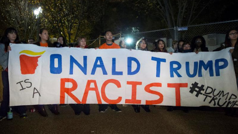 Unos inmigrantes sostienen una pancarta en la que se lee "Donald Trump es un racista" entre un grupo de personas reunidas frente a la Casa Blanca en Washington DC, Estados Unidos. EFE/Michael Reynolds