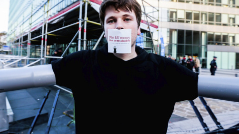 Un activista protesta delante de la sede de la Comisión Europea para protestar contra las subvenciones europeas a la industria armamentística en Bruselas (Bélgica). EFE/Stephanie Lecocq