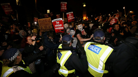 Los partidarios del grupo activista Anonymous plantan cara a la policía de  durante una protesta en Londres, Gran Bretaña 5 de noviembre de 2015. Miles de manifestantes participaron en la marcha 'Million Mask' en la capital el jueves . REUT