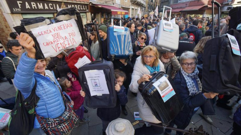 Los ciudadanos de Venecia, mostrando maletas durante la protesta “Venexodus” en la ciudad italiana. / EFE