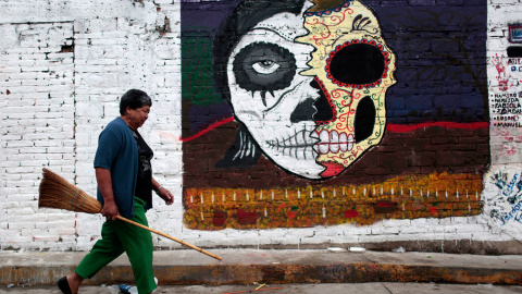 Una mujer lleva una escoba para limpiar las tumbas en el cementerio de Tixtla, estado de Guerrero, México, durante la celebración del Día de Todos los Santos el 1 de noviembre de 2015. AFP PHOTO / Pedro PARDO