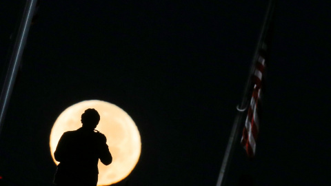 Un hombre toma una fotografía de la superluna en Washington / REUTERS