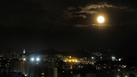 La luna sale tras las nubes por encima de la ciudad alicantina de Benidorm.EFE/Manuel Lorenzo