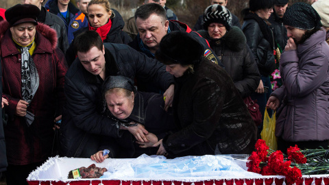 Familiares de un minero, Dmitri Aleksandriv, lloran junto a su ataúd. 33 mineros perdieron la vida tras una explosión en una mina de carbón, en la ciudad ucraniana de Donetsk, cerca del frente de batalla en el este del país. /MARKO DJURICA 