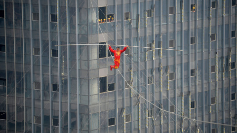 Un acróbata cruza la cuerda floja sobre la Plaza Wanda en Taiyuan (China). / JON WOO (REUTERS)