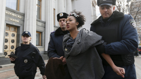 Policías ucranianos arrestan a una activista del movimiento Femen durante una protesta contra la homofobia delante del Parlamento en Kiev (Ucrania), en la que han reclamando que se corrija el Códido Laboral del país para asegurar la armoniz