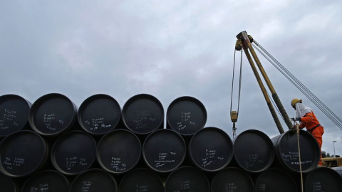 Un operario trabaja junto a los barriles de petróleo. REUTERS Un operario trabaja junto a los barriles de petróleo. REUTERS