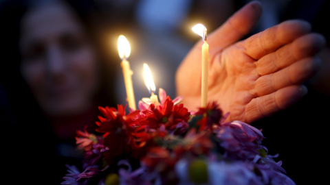 Una mujer sostiene flores y velas durante una procesión religiosa para conmemorar "El Día de 100.000 mártires" en Tbilisi, Georgia. REUTERS/David Mdzinarishvili