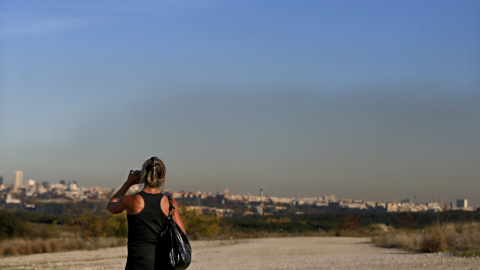 Una mujer hace una foto a la 'boina' de contaminación sobre Madrid debido a los altos niveles de dióxido de nitrógeno. EFE/Juan Carlos Hidalgo