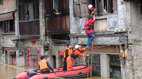 Los equipos de rescate tratan de slavar una mujer de un área inundada después de fuertes lluvias en Hezhou, China. REUTERS/Stringer