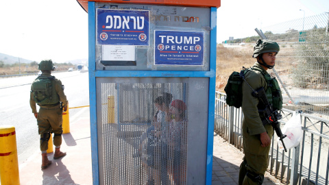 Soldados israelíes al lado de una parada de autobús con carteles de la rama israelí del Partido Republicano de EEUU a favor de Donald Trump, cerca del asentamiento judío de Ariel en Cisjordania. REUTERS / Baz Ratner Soldados israelíes al lado de una parada de autobús con carteles de la rama israelí del Partido Republicano de EEUU a favor de Donald Trump, cerca del asentamiento judío de Ariel en Cisjordania. REUTERS / Baz Ratner