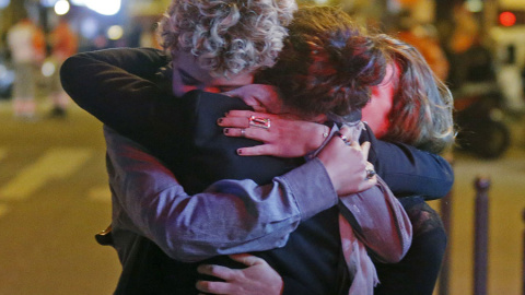 Tres personas se abrazan al lado de la sala de fiestas Bataclan, en París. REUTERS/Christian Hartmann