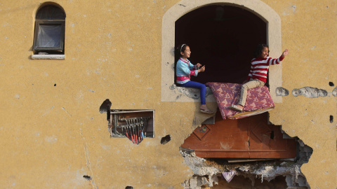 Dos niñas palestinas juegan en su casa, que quedó prácticamente derruida durante la operación 'Margen Protector' llevada a cabo por Israel el pasado verano. / REUTERS