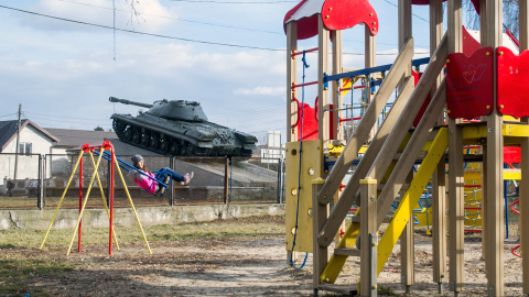 Un tanque pasa junto a un parque infantil en Kagarlyk, Ucrania. / AFP