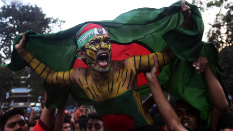 Aficionado al cricket en Bangladesh sotiene la bandera de su país. / AFP