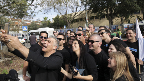 El líder del partido laico centrista Yesh Atid (Hay Futuro), Yair Lapid, junto a su mujer y partidarios se hace un 'selfie' durante las elecciones de Israel./ REUTERS