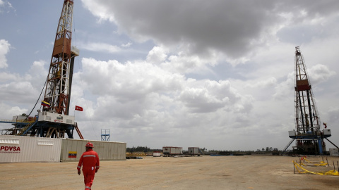 FILE PHOTO: An oilfield worker walks next to drilling rigs at an oil well operated by Venezuela's state oil company PDVSA, in the oil rich Orinoco belt, near Morichal at the state of Monagas FILE PHOTO: An oilfield worker walks next to drilling rigs at an oil well operated by Venezuela's state oil company PDVSA, in the oil rich Orinoco belt, near Morichal at the state of Monagas April 16, 2015. REUTERS/Carlos Garcia Rawlins/Fil
