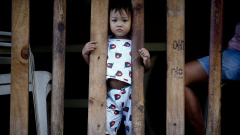 Un niño permanece en su casa de la barriada de Navotas, mientras los líderes llgean a la Cumbre del Foro de Cooperación Económica Asia-Pacífico (APEC) que se celebra en Manila, Filipinas, el 18 de noviembre del 2015. Líderes de 21 países as