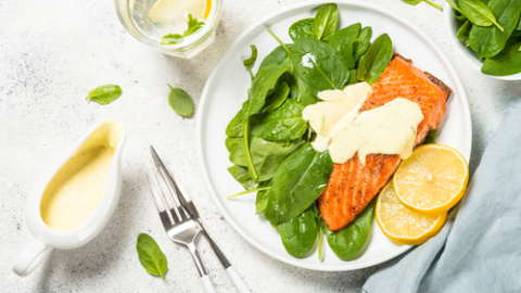 Salmón con salsa de yogur sobre cama de espinacas frescas. Salmón con salsa de yogur sobre cama de espinacas.