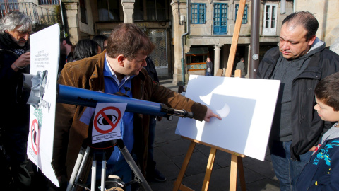 Varias personas en Pontevedra, utilizan un telescopio para observar el eclipse parcial de sol. REUTERS/Miguel Vidal