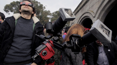 Numerosas personas, pertrechadas de diversos artilugios, se acercaron a ver el eclipse de sol deslucido por la nubosidad a los pies Casa de las Ciencias en A Coruña, en Galicia. EFE/Cabalar