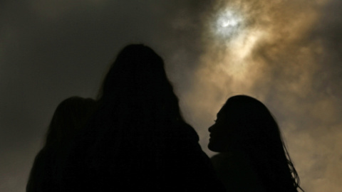 Unas personas observan desde el Zoo de Belfast el eclipse parcial de sol. REUTERS/Cathal McNaughton