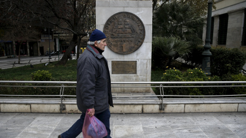 Un hombre pasa junto a una réplica de un dracma, la monedz griega antes del euro, junto al Ayuntamiento de Atenas.. REUTERS/Alkis Konstantinidis Un hombre pasa junto a una réplica de un dracma, la monedz griega antes del euro, junto al Ayuntamiento de Atenas.. REUTERS/Alkis Konstantinidis