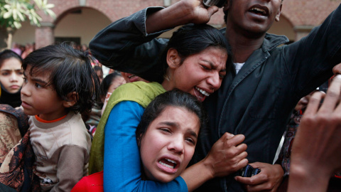 Varias personas lloran la muerte de un familiar, víctima de un atentado suicida contra una iglesia, durante su funeral en Lahore. /MOHSIN RAZA (REUTERS)