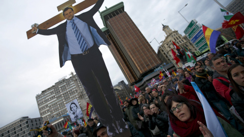 Un manifestante sostiene una imagen del presidente del Gobierno, Mariano Rajoy,  crucificado, durante la concentración de las Marchas de la Dignidad en la madrileña Plaza de Colón. REUTERS/Sergio Perez