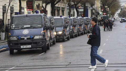 Un hombre pasa junto a las furgonetas policiales desplegadas en la Calle Goya, junto a la Plaza de Colón, punto de llegada de las Marchas por la Dignidad. EFE/Ballesteros