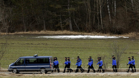 Un grupo de gendarmes se dirigen a pie a la base de operaciones en localidad francesa de Seyne-les-Alpes, donde se han concentrado los servicios de socorro./ EFE