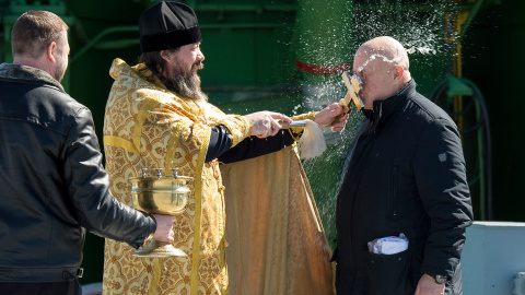 Un sacerdote ortodoxo bendice a un miembro de las fuerzas de búsqueda y recuperación tras haber bendecido el cohete Soyuz en la plataforma de lanzamiento Cosmódromo de Baikonur. /NASA