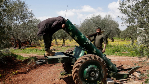 Un rebelde sirio mira dentro de un cañón en el norte de Siria. /KHALIL ASHAWI (REUTERS)