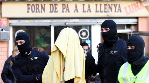 Agentes de la Guardia Civil escoltan al hombre que, junto a su mujer y a sus dos hijos gemelos, han sido detenidos en Badalona por su presunta relación con una red de envío de yihadistas a Siria. EFE/Toni Garriga