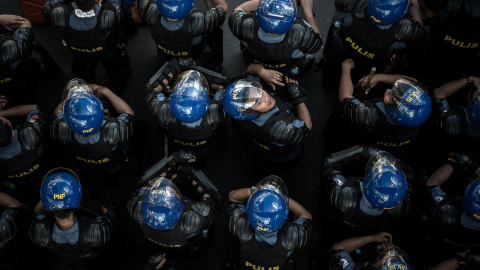 Un policía de Filipinas mira hacia arriba tras una manifestación en contra de la (APEC) Cumbre de Cooperación Económica Asia-Pacífico en Manila el 19 de noviembre de 2015. AFP/PHILIPPE LOPEZ