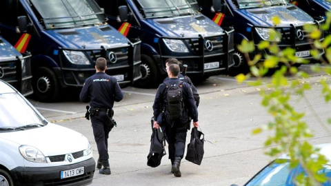 Agentes de la Policía Nacional se dirigen hacia los furgones policiales. EFE/Víctor Lerena