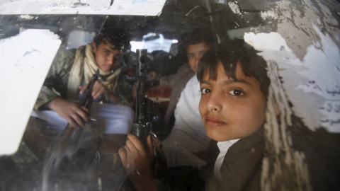 Niños con rifles mientras conducen un coche para una manifestación contra los ataques saudíes en la capital de Yemen. REUTERS/Khaled Abdullah