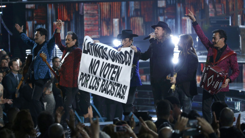 'Mana' junto al grupo 'Los tigres del norte' agarran una pancarta durante su actuación "Somos más americanos" en los Latin Grammy Awards (Las Vegas). REUTERS/Mario Anzuoni