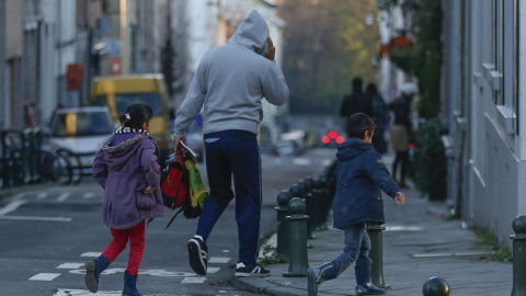 Un padre regresa a casa con sus hijos después de descubrir que la escuela está cerrada en Bruselas (Bélgica). EFE/Laurent Dubrule