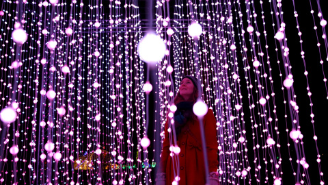 Una mujer entre la iluminación del photo-call navideño para el 'Kew Festival' en Londres. REUTERS/Neil Hall