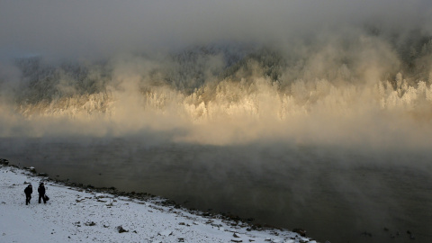 Unos escolares caminan a lo largo de la orilla del río Yenisei, cubierto con una niebla helada, a menos 26 grados bajo cero, en la ciudad siberiana de Divnogorsk cerca de Krasnoyarsk, Rusia. REUTERS/Ilya Naymushin