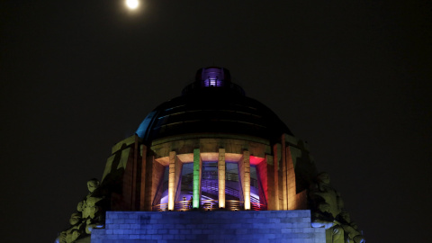 La luz de la luna ilumina la cúpula del Monumento a la Revolución en Ciudad de México donde están reflejados los colores de la bandera homosexual tras las declaraciones del alcalde de Ciudad de México que catalogan a ésta como la capital me