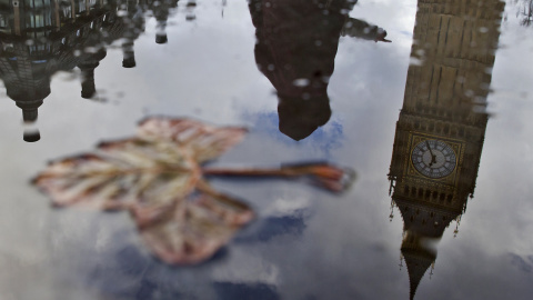 El "Big Ben", se refleja en un charco cerca del Palacio de Westminster, en el centro de Londres, momentos antes de que el el canciller británico de Hacienda, George Osborne, presentase los presupuestos de los departamentos del gobierno para