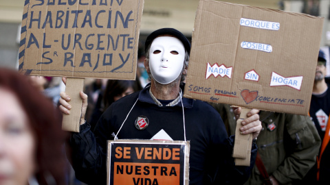 Un manifestante sujeta pancartas en la protesta convocada por la plataforma "Nadie sin Hogar" defendiendo el derecho a la vivienda en el centro de Madrid, España, 26 de noviembre de economía 2015. REUTERS / Paul Hanna