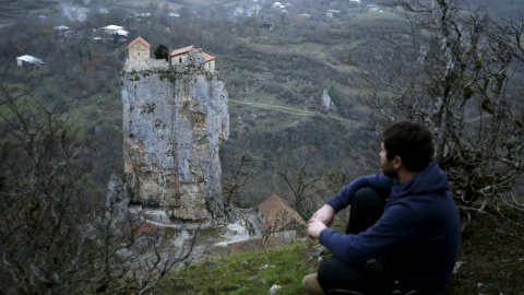 Un lugareño observa una iglesia en el punto más alto del Pilar de Katskhi de 40 metros de altura, en el pueblo de Katskhi, Georgia. REUTERS/David Mdzinarishvili