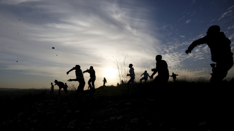 Protestantes palestinos lanzan piedras hacia las tropas israelíes en la ciudad de Ramallah. REUTERS/Mohamad Torokman