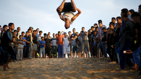 Un joven palestino muestra sus habilidades en el campamento de refugiados de la ciudad de Gaza. REUTERS/Mohammed Salem
