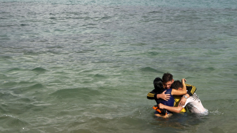 Un inmigrante cubano abraza a su hija y a su amigo después de que esta cruzase la frontera desde Colimbia a través del río La Miel. Provincia de Guna Yala. REUTERS/Carlos Jasso